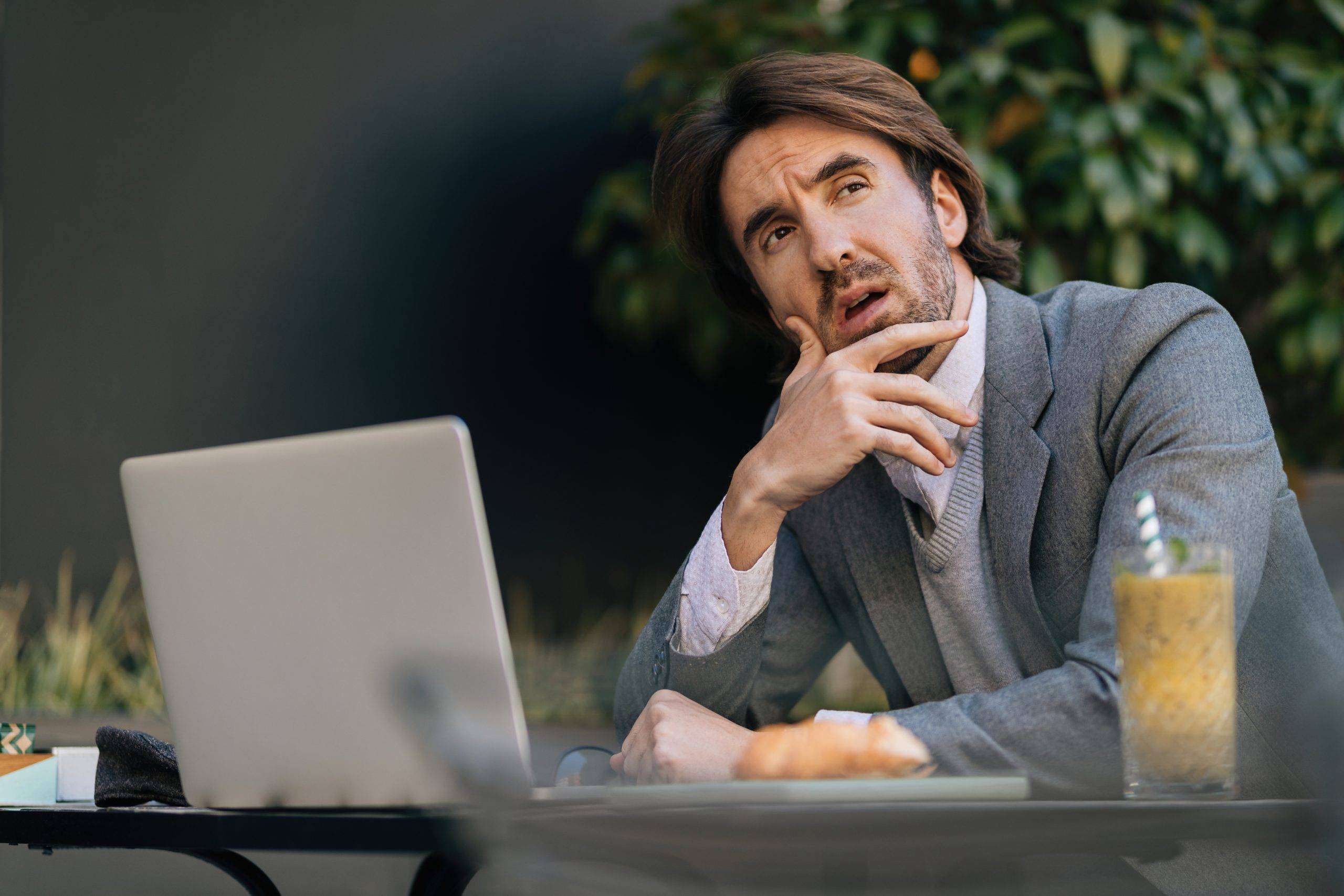 young entrepreneur thinking something while sitting outdoor cafe looking away scaled TOP 5 MISTAKES NEW IMPORTERS MAKE (AND HOW TO AVOID THEM)